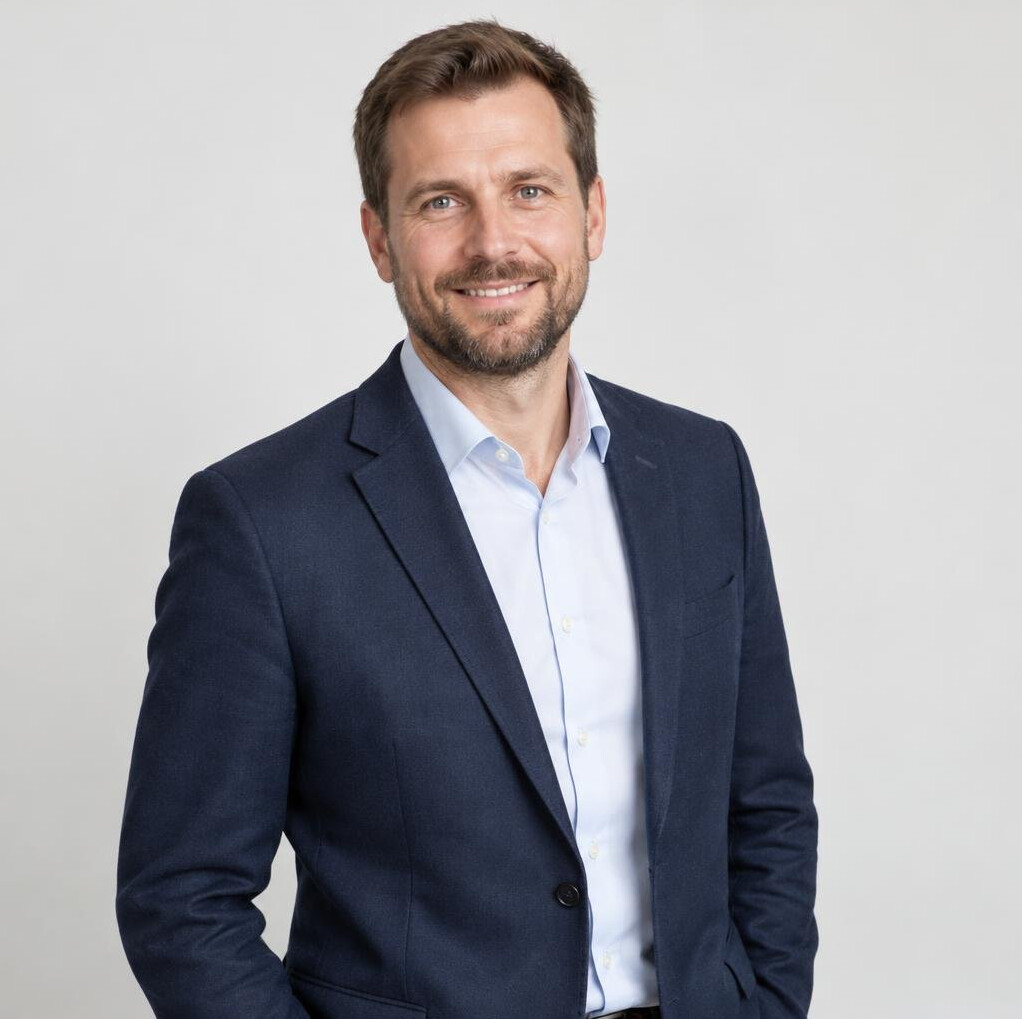 Portrait of a smiling man in his late thirties with short brown hair and a beard
